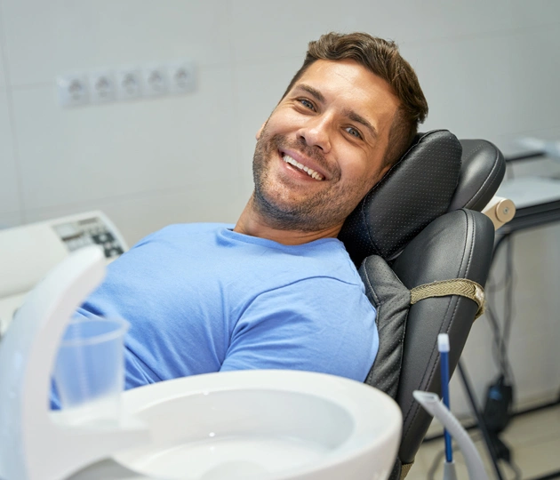 Smiling man in blue shirt seated in dental chair at Spring View Dental office.