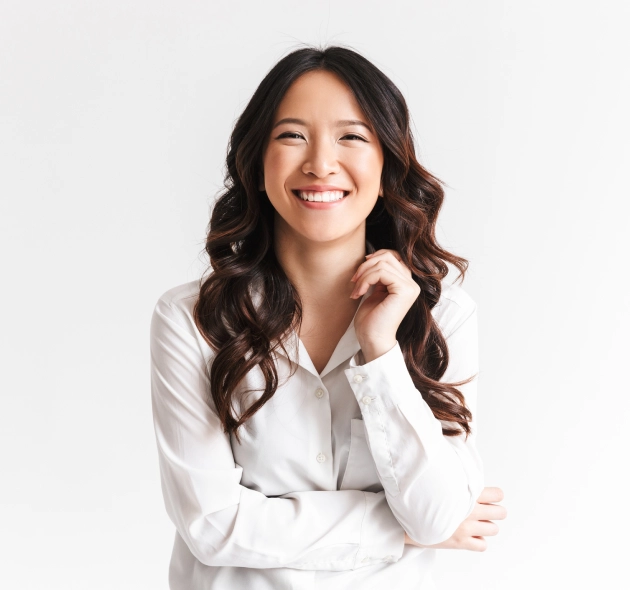 Professional woman in white blouse smiling at camera, dental practice headshot portrait.
