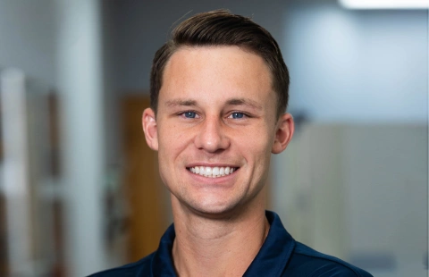 Smiling male dental professional in dark shirt against blurred office background at Spring View Dental.